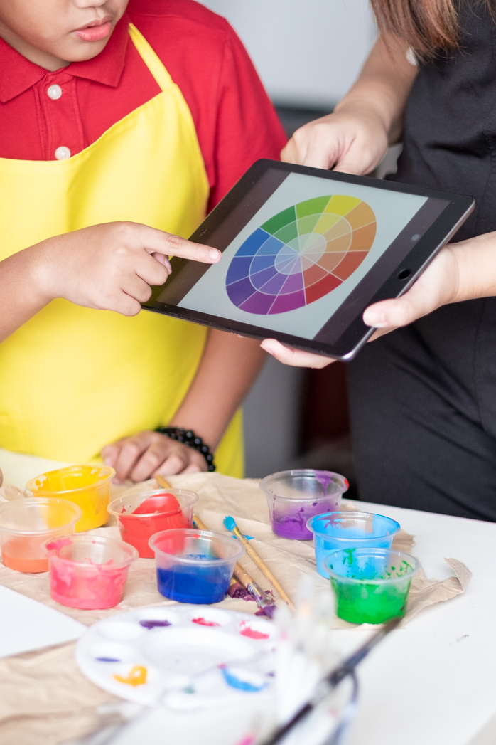 Little Boy Pointing at Color Wheel on Teacher's Tablet